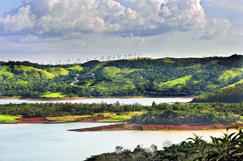 West shore of Lake Arenal with new hotel and wind turbines