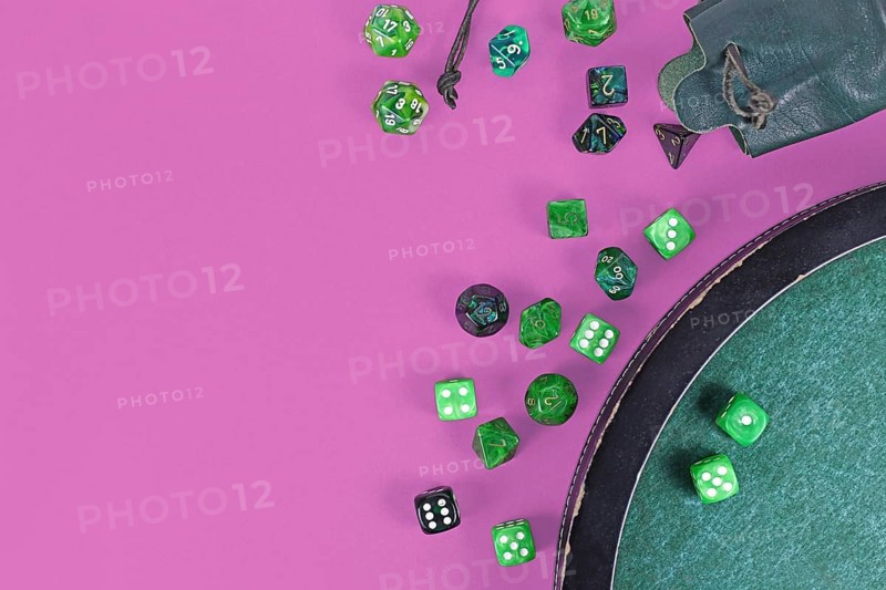 Different green roleplaying dices on purple background