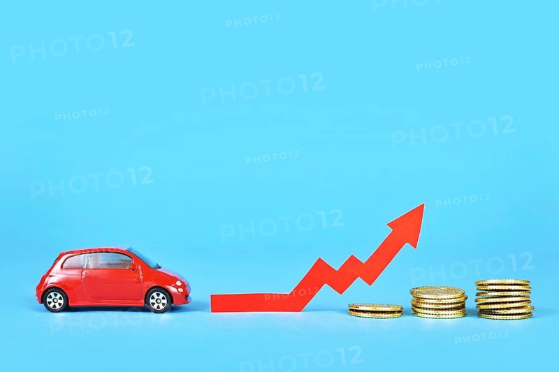 Small car with rising arrow and money coins on blue background