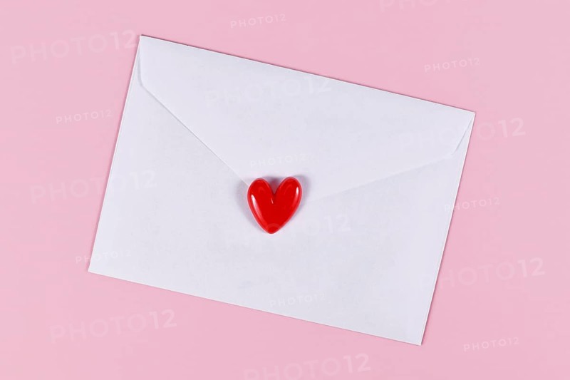 Love letter. White envelope with single red heart on pink background