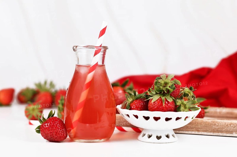 Red strawberry fruit lemonade in jar with raw berries