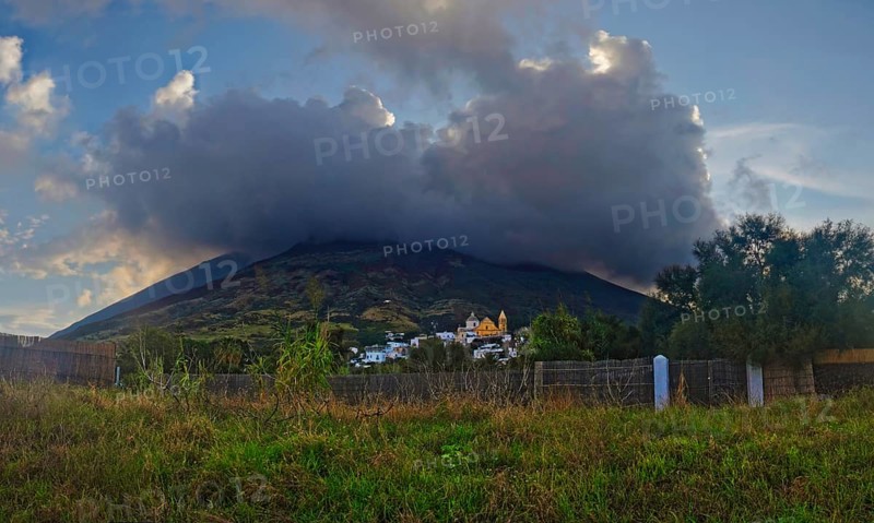 Small fishing village and harbour of San Vincenzo in front of the volcanic cone of Stromboli at sunset