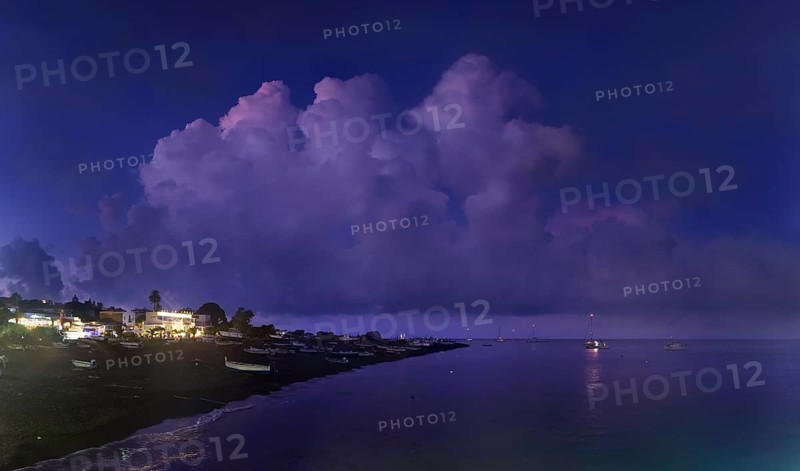 Beach of the fishing village San Vincenzo with fishing boats at sunset and bizarre cloudscape