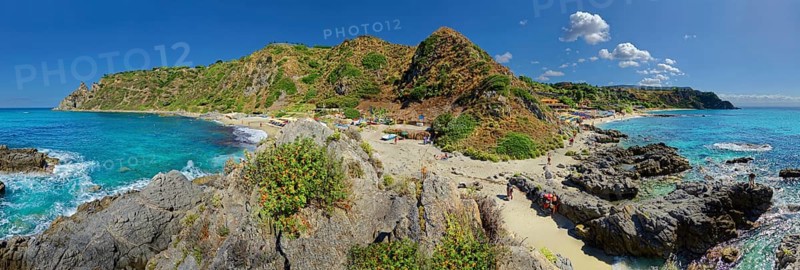 Panorama at the sandy beach and bay Capo Vaticano with turquoise sea and bizarre sky