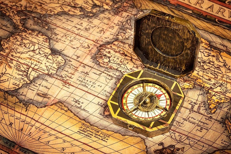 Vintage pirate retro compass on ancient world map