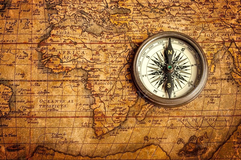 Old vintage retro compass on ancient map