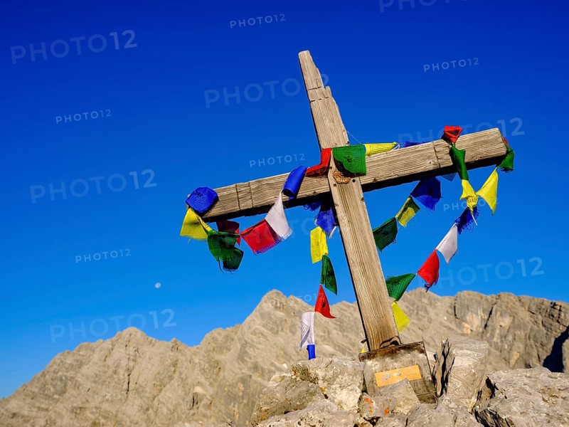 Buddhist prayer flags at the summit cross of the Kleiner Watzmann
