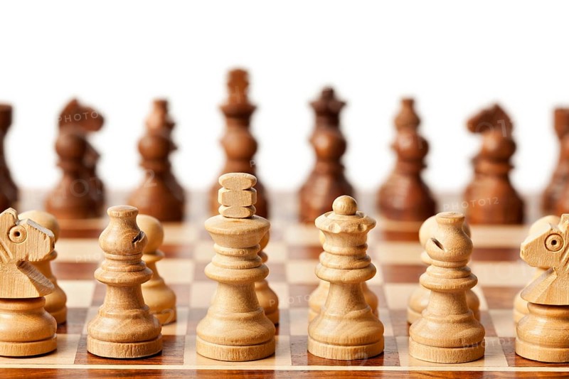 Wooden chess pieces on chessboard. Selective focus