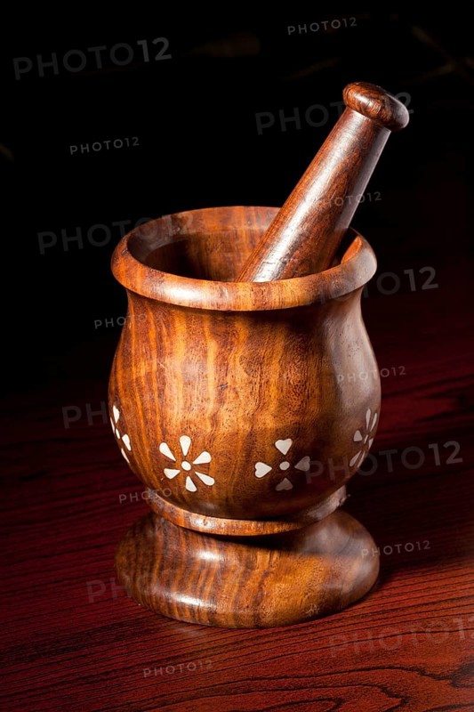 Wooden mortar and pestle on dark wood background