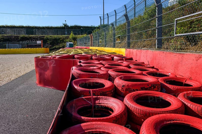 Safety measure for car racing Impact protection red yellow coloured tyre piles next to gravel bed in turn 8 of racetrack for motorsport