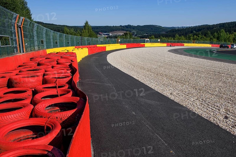 Safety measure for car racing Impact protection red yellow coloured tyre piles next to gravel bed in turn 8 of racetrack for motorsport