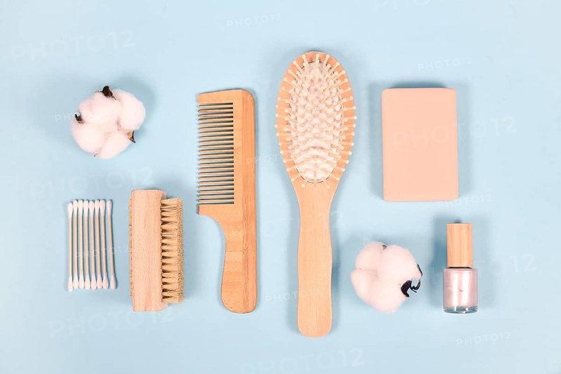 Eco friendly wooden beauty and hygiene products like comb and soap on blue background