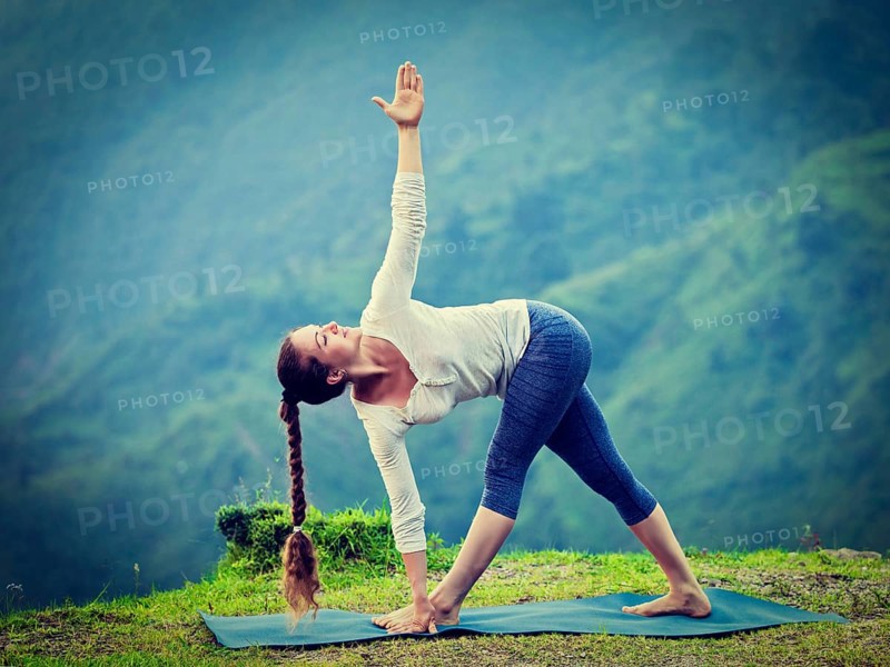 Vintage retro effect hipster style image of woman doing Ashtanga Vinyasa yoga asana Parivrtta trikonasana