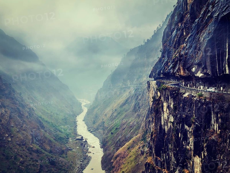 Vintage retro effect filtered hipster style image of car on dangerous road in Himalayas mountains in gorge above precipice
