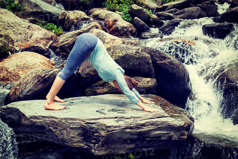 Vintage retro effect hipster style image of sporty fit woman doing yoga asana Adho mukha svanasana