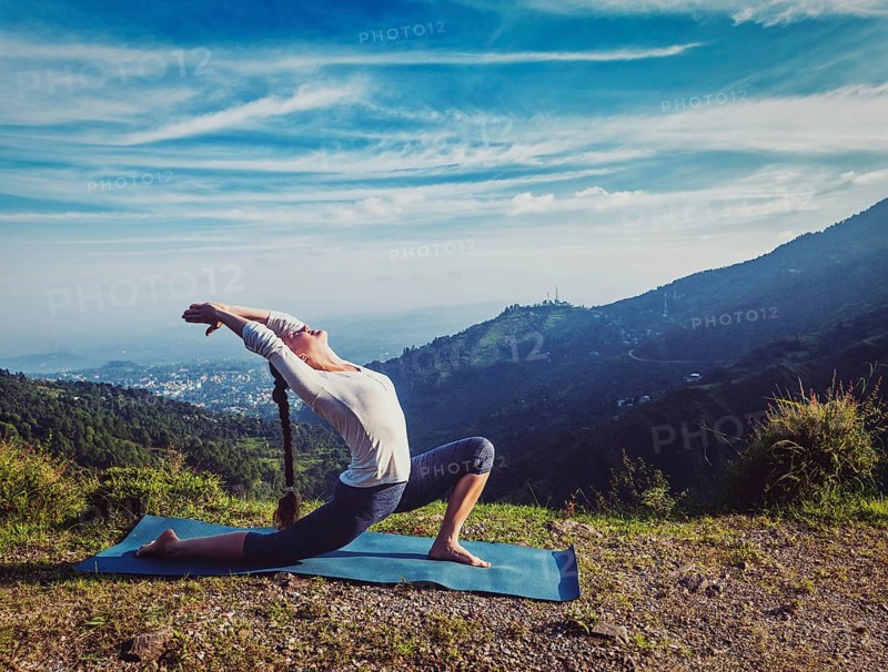 Vintage retro effect hipster style image of sporty fit woman practices yoga Anjaneyasana