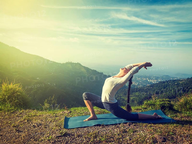 Vintage retro effect hipster style image of sporty fit woman practices yoga Anjaneyasana