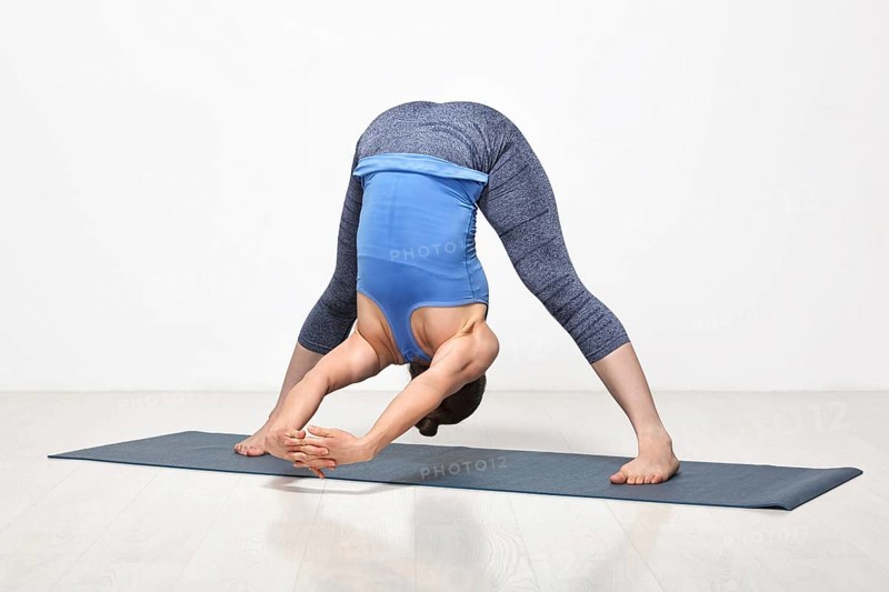 Beautiful sporty fit woman practices Ashtanga Vinyasa yoga asana Prasarita padottanasana C