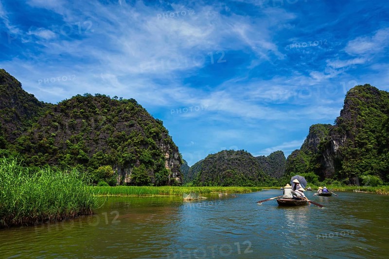 Tourists on boats in Tam Coc-Bich Dong Ngo Dong river in popular tourist destination near Ninh Binh