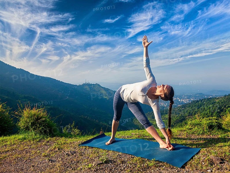 Woman doing Ashtanga Vinyasa yoga asana Utthita trikonasana