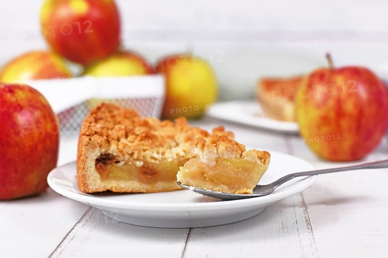Piece of traditional European apple pie with topping crumbles called 'Streusel' on dessert spoon
