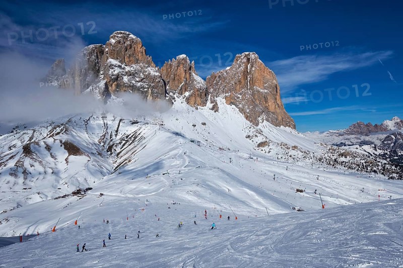 View of a ski resort piste with people skiing in Dolomites in Italy