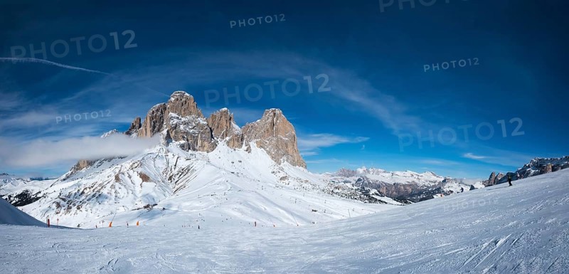 Panoramaof a ski resort piste with people skiing in Dolomites in Italy