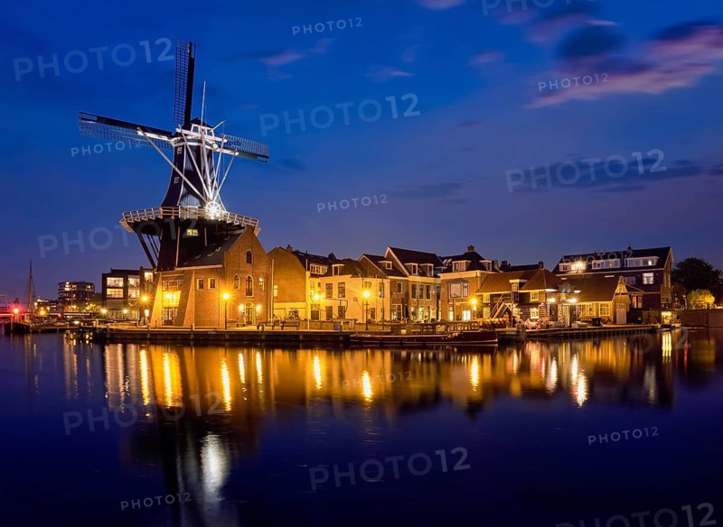 View of Harlem landmark windmill De Adriaan on Spaarne river in the night illuminated. Harlem