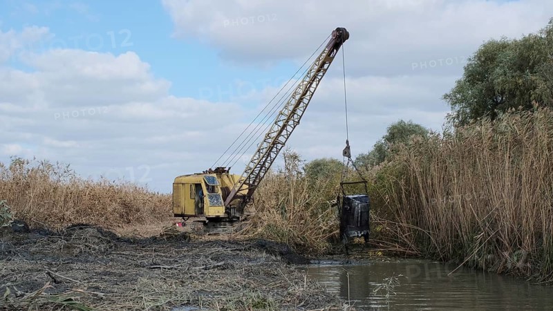 Excavator deepens and widens the canal between the Danube River and the lakes