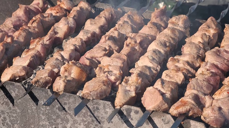 Process of cooking yummy shashlik in nature. Delicious food on metal skewer in bbq. Kebab