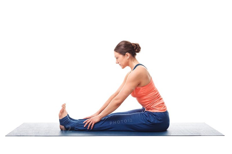 Sporty fit woman doing Ashtanga Vinyasa yoga back bending asana Paschimottanasana