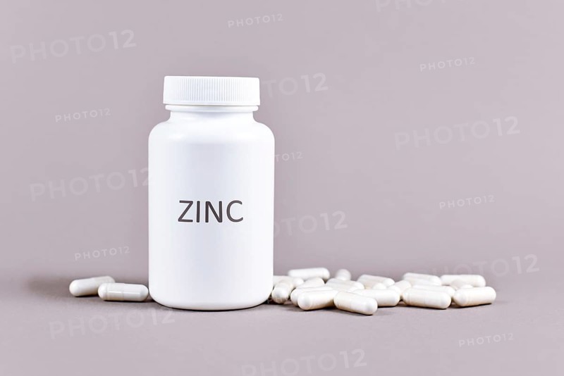 Bottle with Zinc mineral supplement inscription with capsules