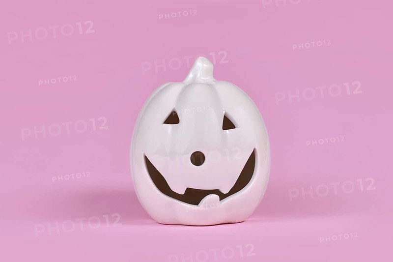 Single Pumpkin decoration with face on pink background