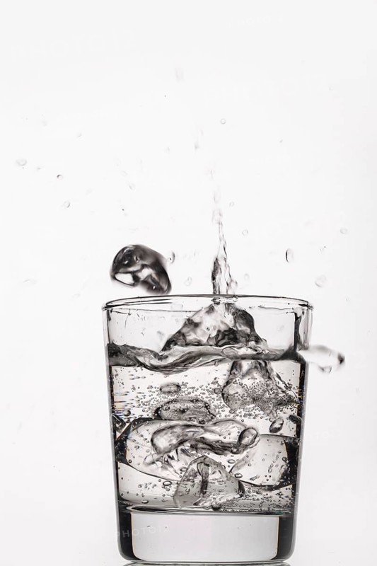 Crystals of ice falling into the glass of water