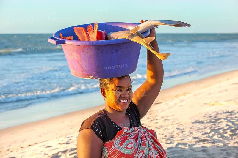 Malagasy woman carrying fish in a bowl on her head