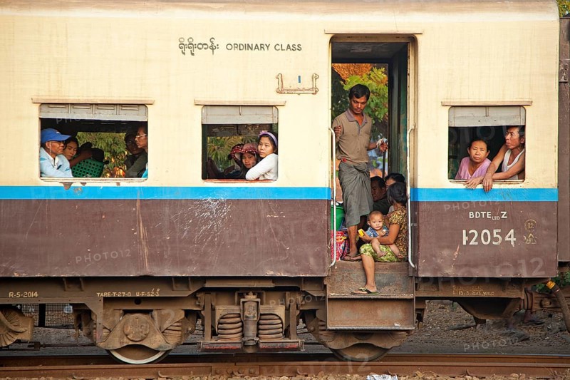 Burmese passengers in a normal class carriage of an old British train in Myanmar