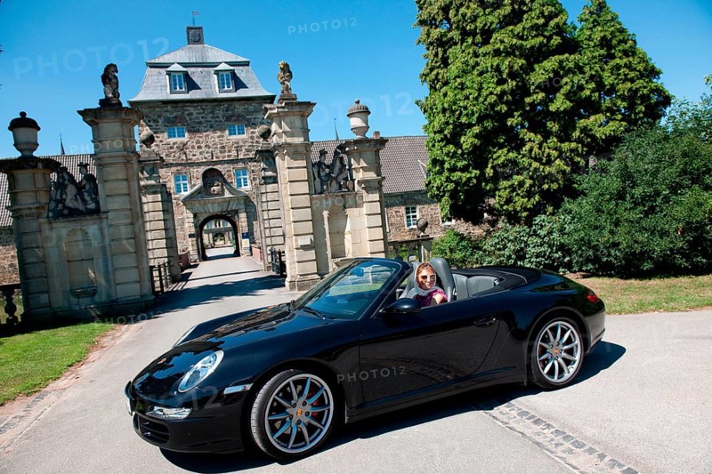 Woman with Porsche 911 cabriolet in front of castle