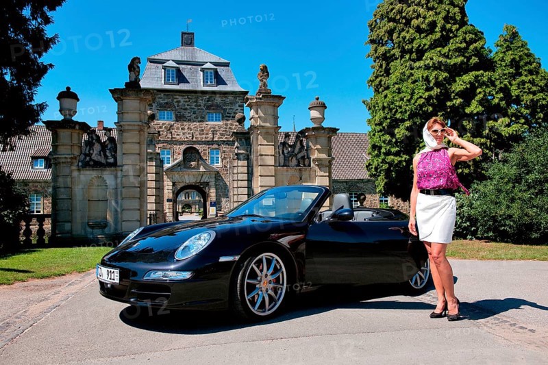 Woman with Porsche 911 cabriolet in front of castle
