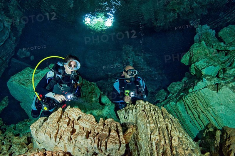 Diver under water in cave entrance of a freshwater cave