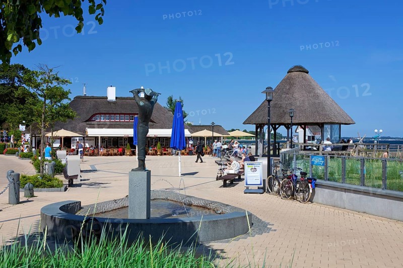 Statue and cafe-restaurant on the promenade in the seaside resort of Haffkrug