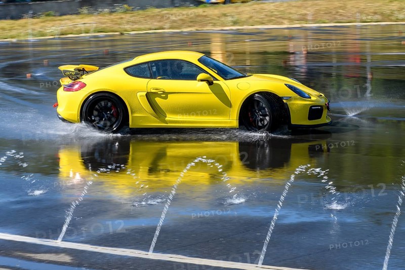 Sports car racing car Porsche Cayman GT4 on rain track drifting drifting across wet asphalt during driving safety training