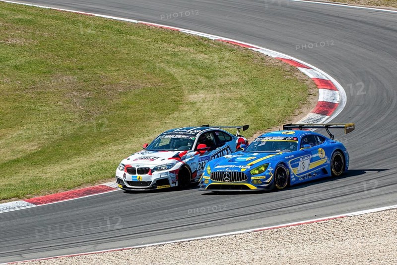 BMW M235i Racing is overtaken on the outside by Mercedes-AMG GT3 at 24h Nuerburgring race track 24-hour race