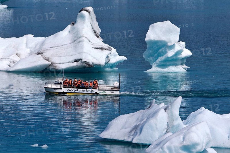 Tourists in an amphibious vehicle between icebergs