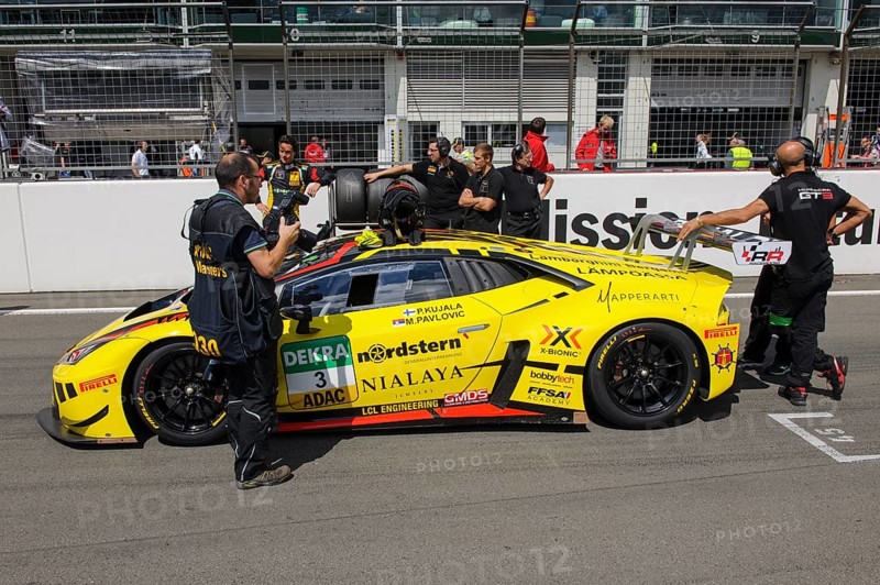 Lamborghini Huracan GT3 with racing team in front of start of car race