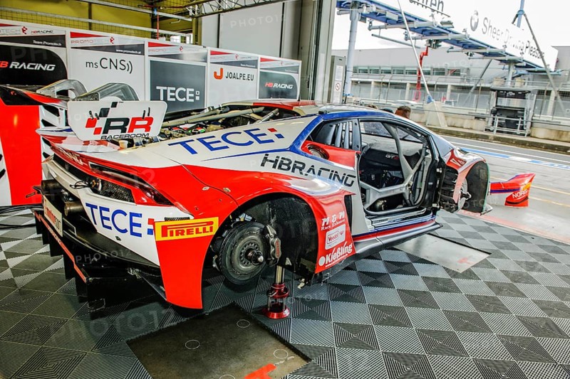 Racing car Lamborghini Huracan GT3 with wheels dismounted without tyres with visible brake disc stands in pit of pit lane at Nuerburgring race track