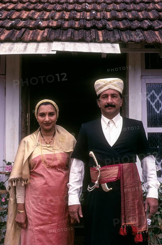 Kodava couple in traditional house in front of their house