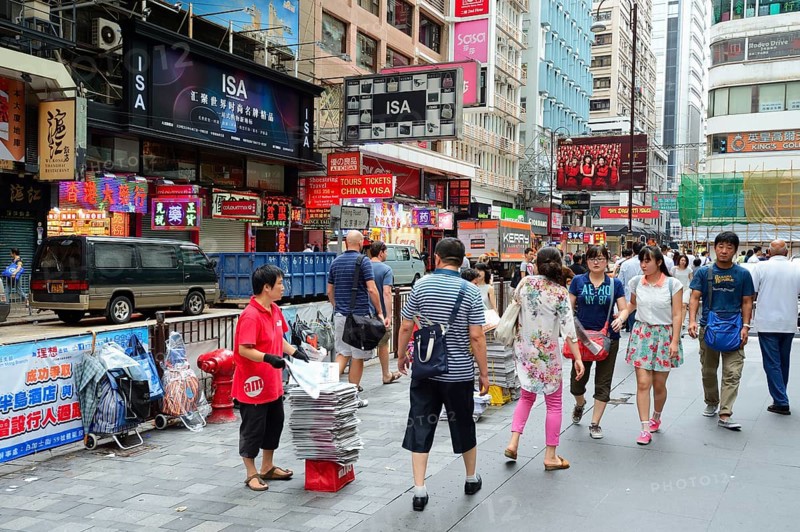 Woman handing out newspapers to passers-by