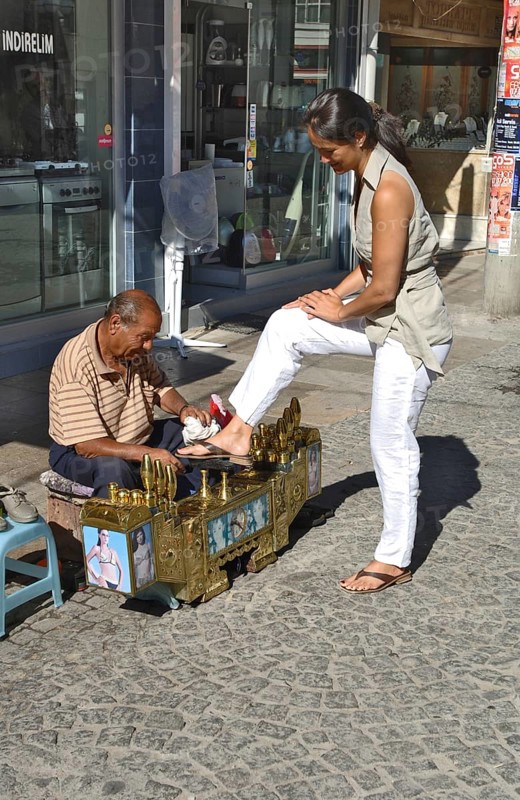 Shoeshine boy with customers
