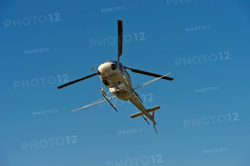 Helicopter Eurocopter AS350 B2 Ecureuil of Air-Glaciers SA with mounted spraying rods in flight