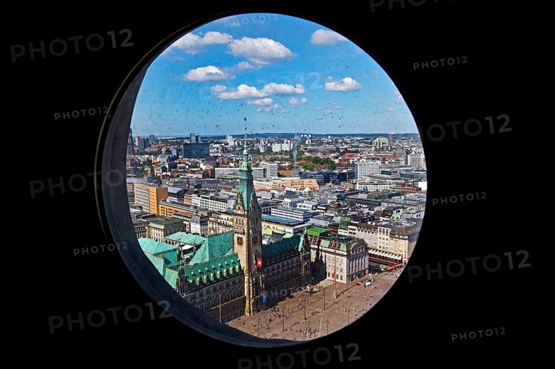 City view with the town hall through the porthole windows in the spire of the main church of St. Petri